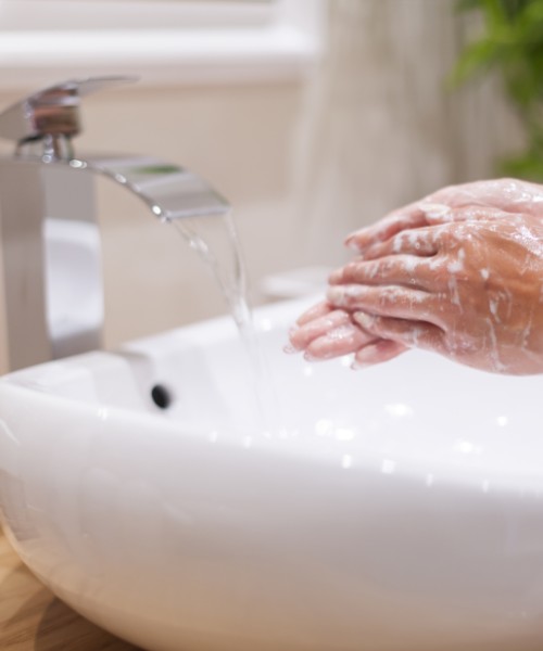 Washing hands over sink that used Drainbo's all natural drain cleaner