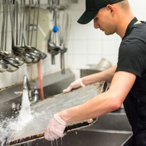 Image of a restaurant employee washing dishes